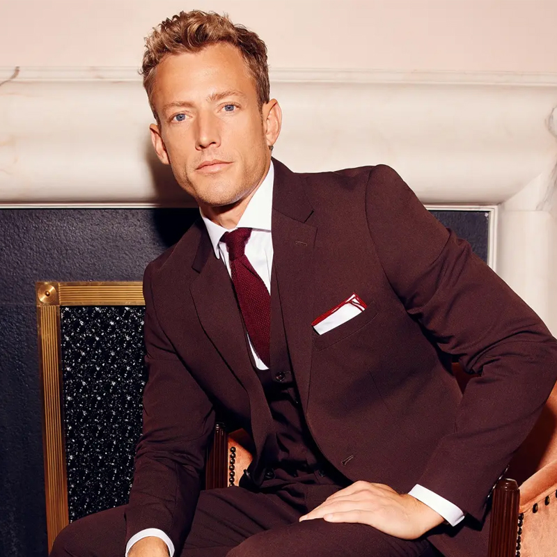 A perfectly finished bespoke suit hanging in a luxurious garment bag